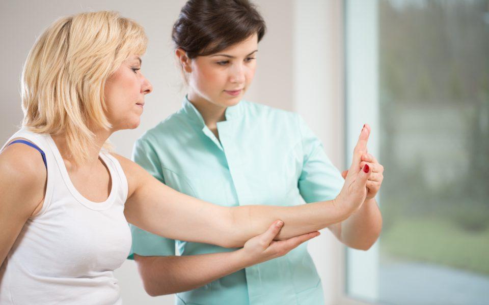 Therapist examining female patient's wrist